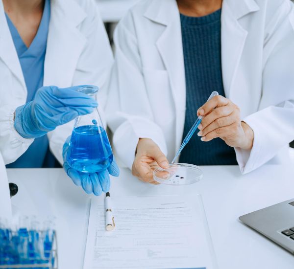 Scientists conducting experiment with blue liquid.